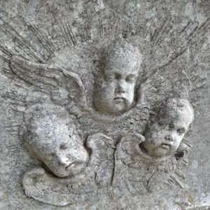 Carved cherub faces on a tomb